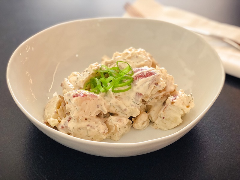 A bowl of chunky, creamy potato salad. 